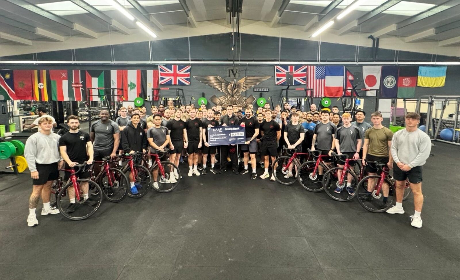 9 Training Support Battalion Royal Electrical and Mechanical Engineers holding the NAAFI cheque